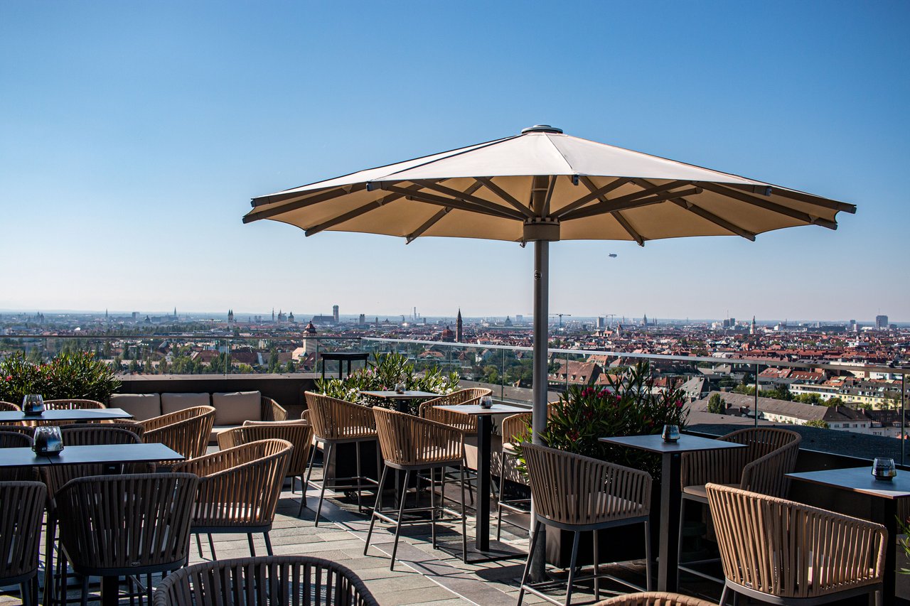 Windfester Mittelstockschirm auf einer Dachterrasse mit Blick über die Stadt
