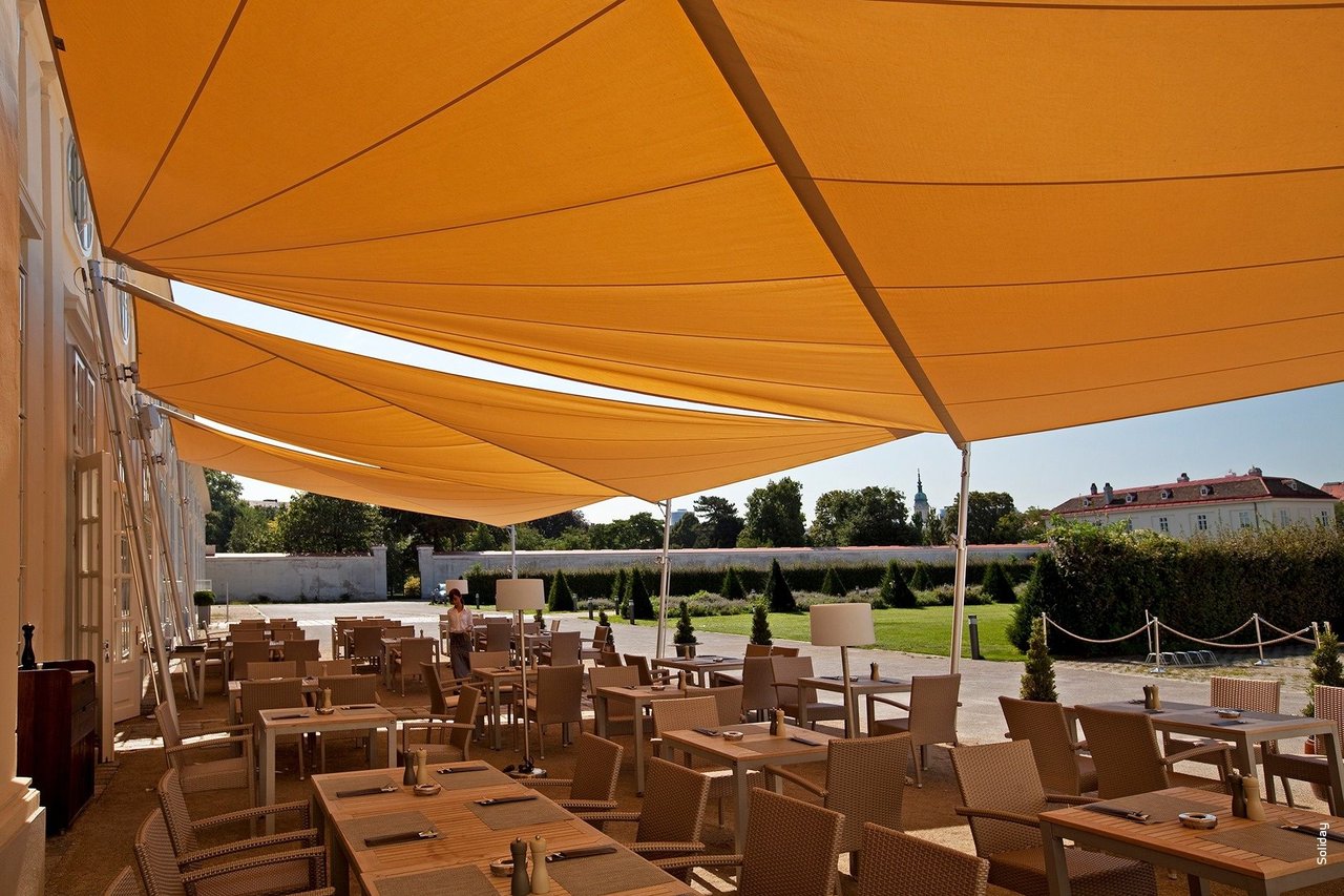 Dreieckiges Sonnensegel über einer Terrasse mit drei Befestigungspunkten