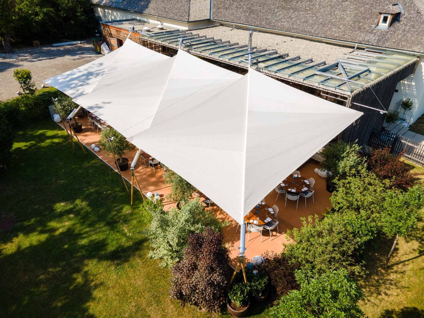 Luftaufnahme: zwei SunSquare Sonnensegel überspannen eine Restaurant-Gartenterrasse