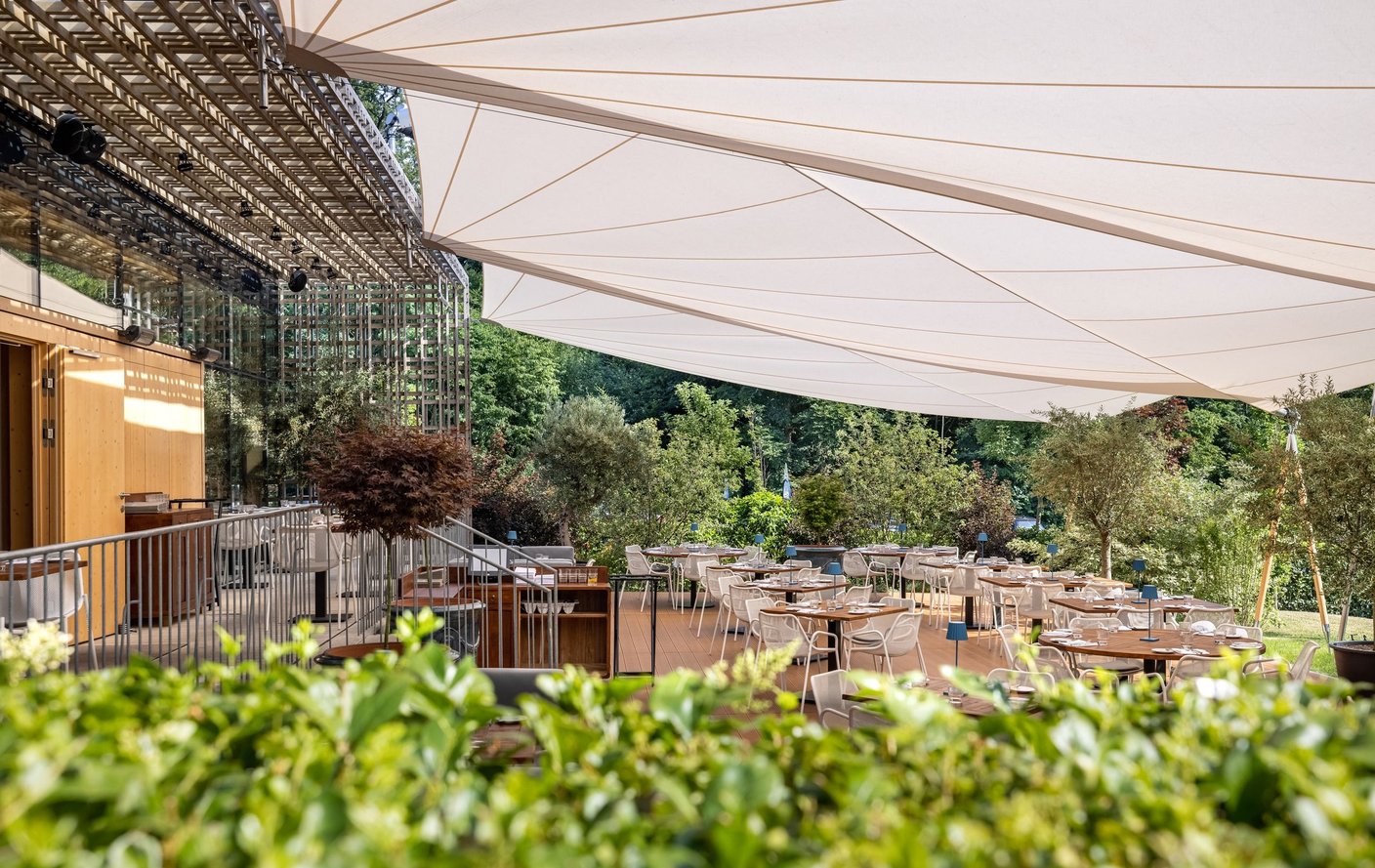 SunSquare Sonnensegel über einer Restaurantterrasse mit Olivenbäumen im Vordergrund