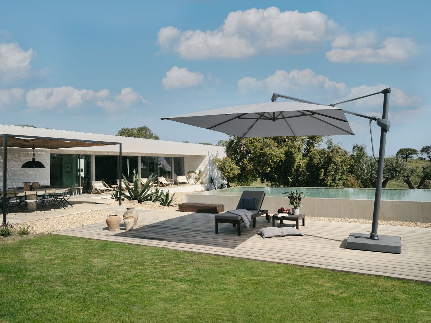 Glatz Sombrano S+ auf flachem Plattensockel an der Pool-Terrasse einer modernen Villa