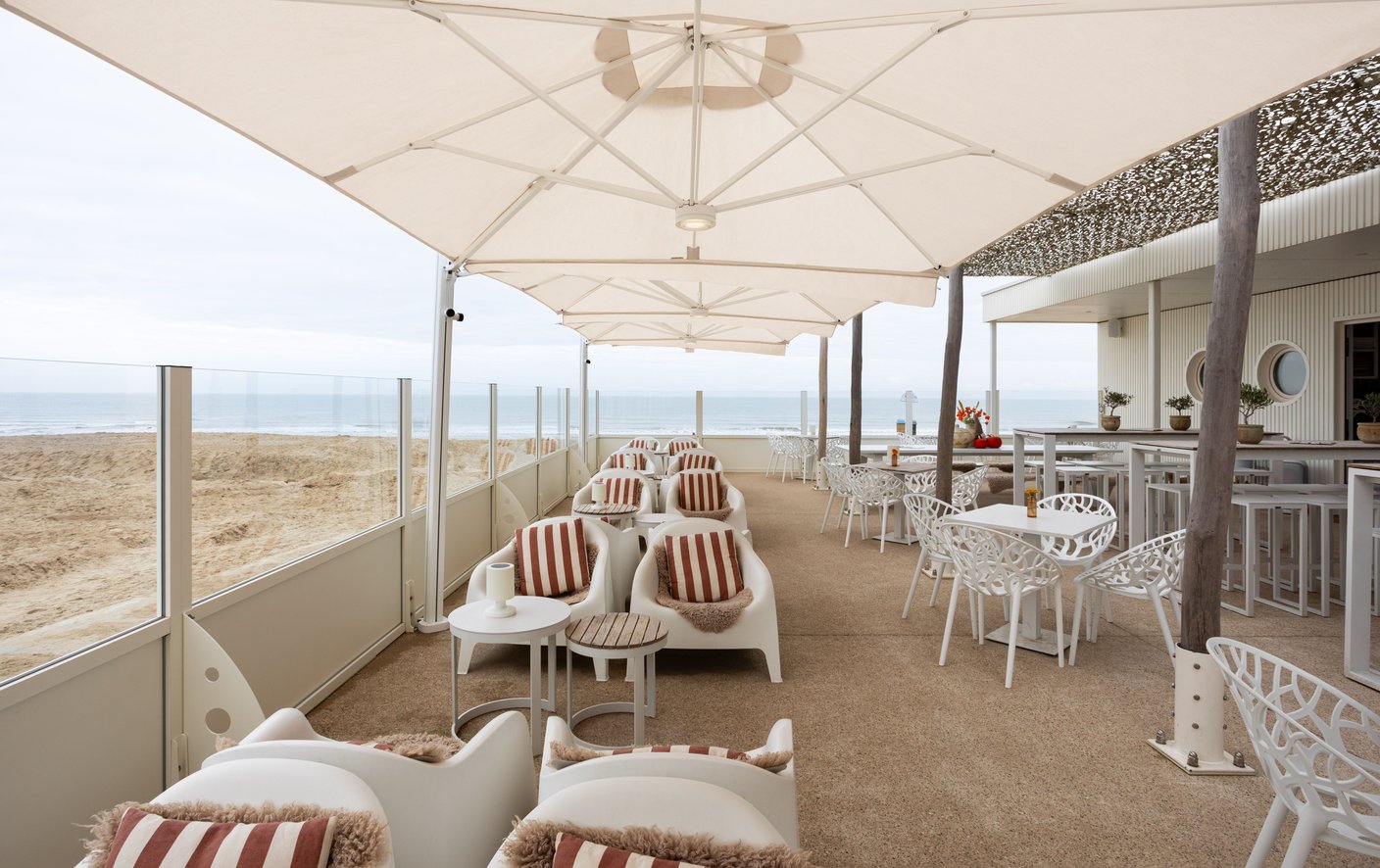 Gekoppelte Prostor P6 Schirmdächer in Reihe über einer Strandlounge