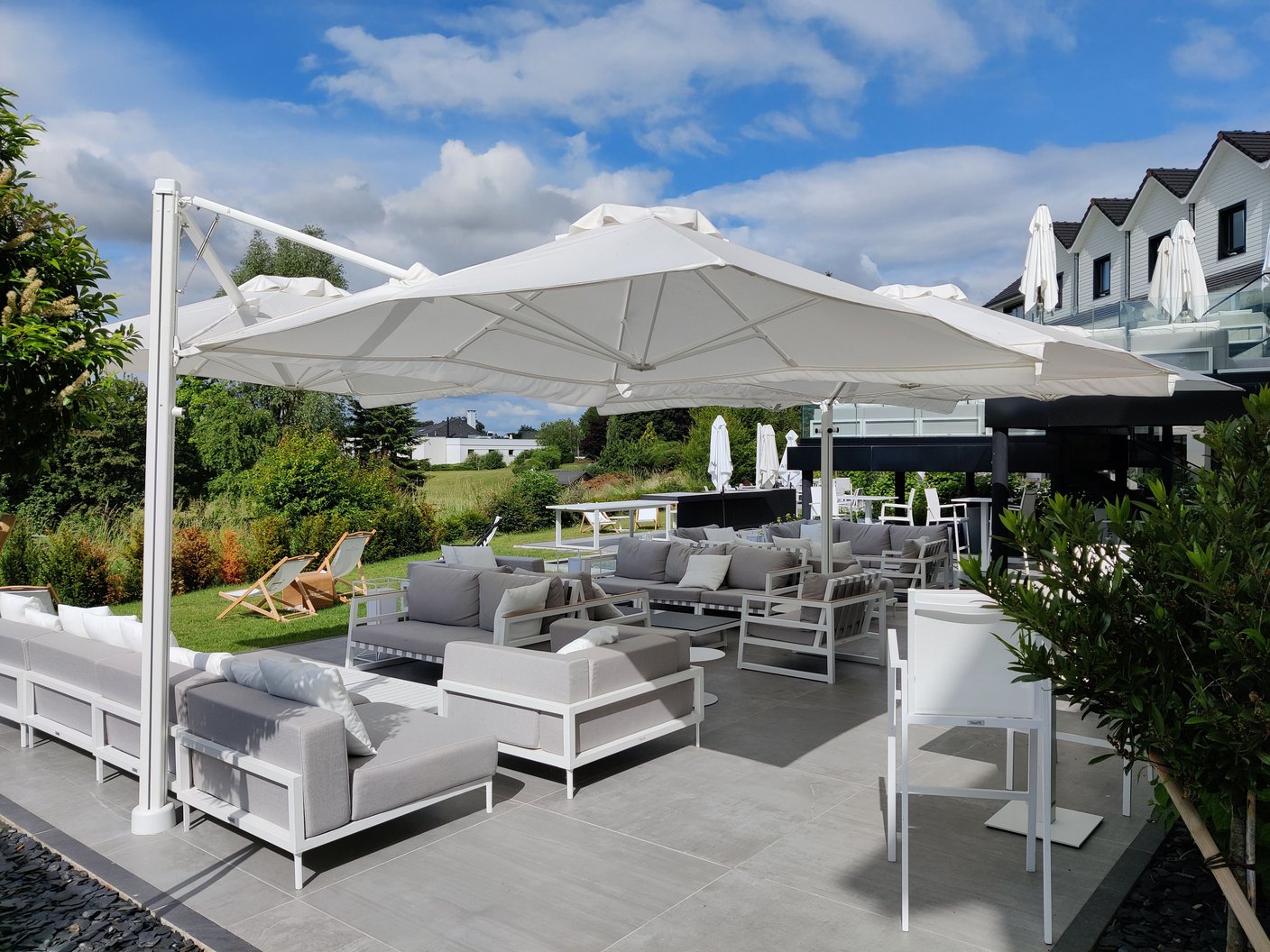 Prostor P6 in Weiß über einer Lounge mit grauen Polstermöbeln auf einer Hotelterrasse