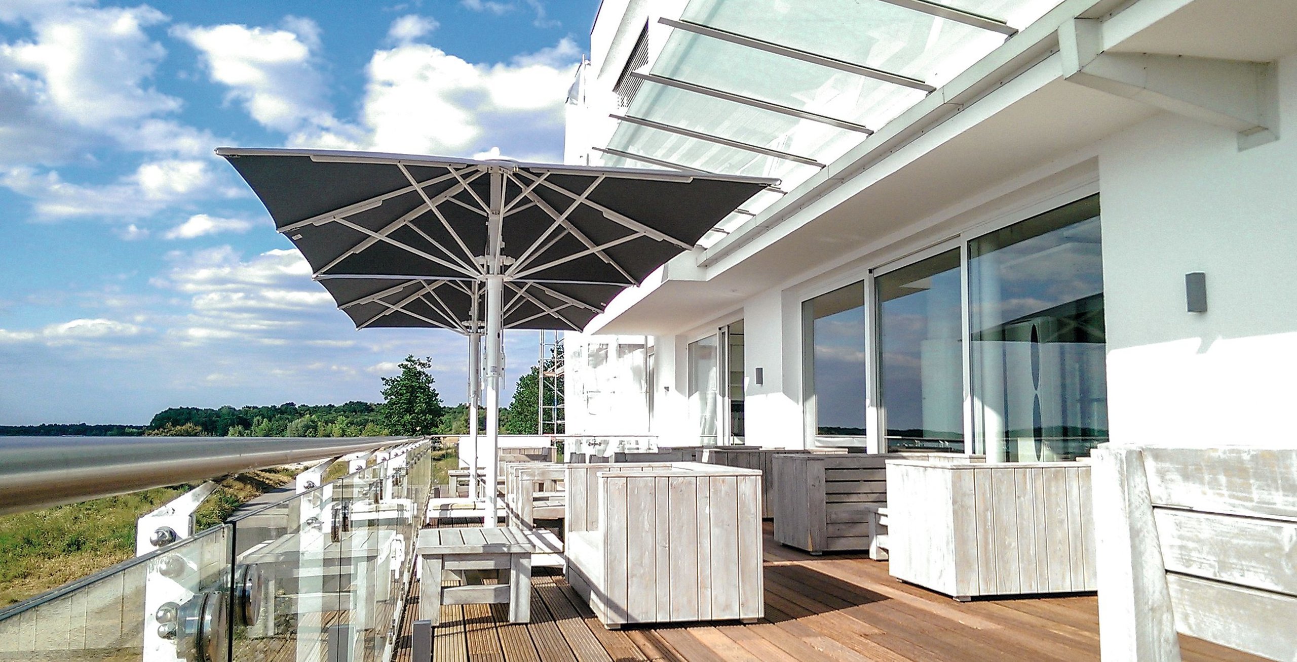 Großer weißer Bahama Jumbrella Großschirm über einer Dachterrasse mit Weitblick