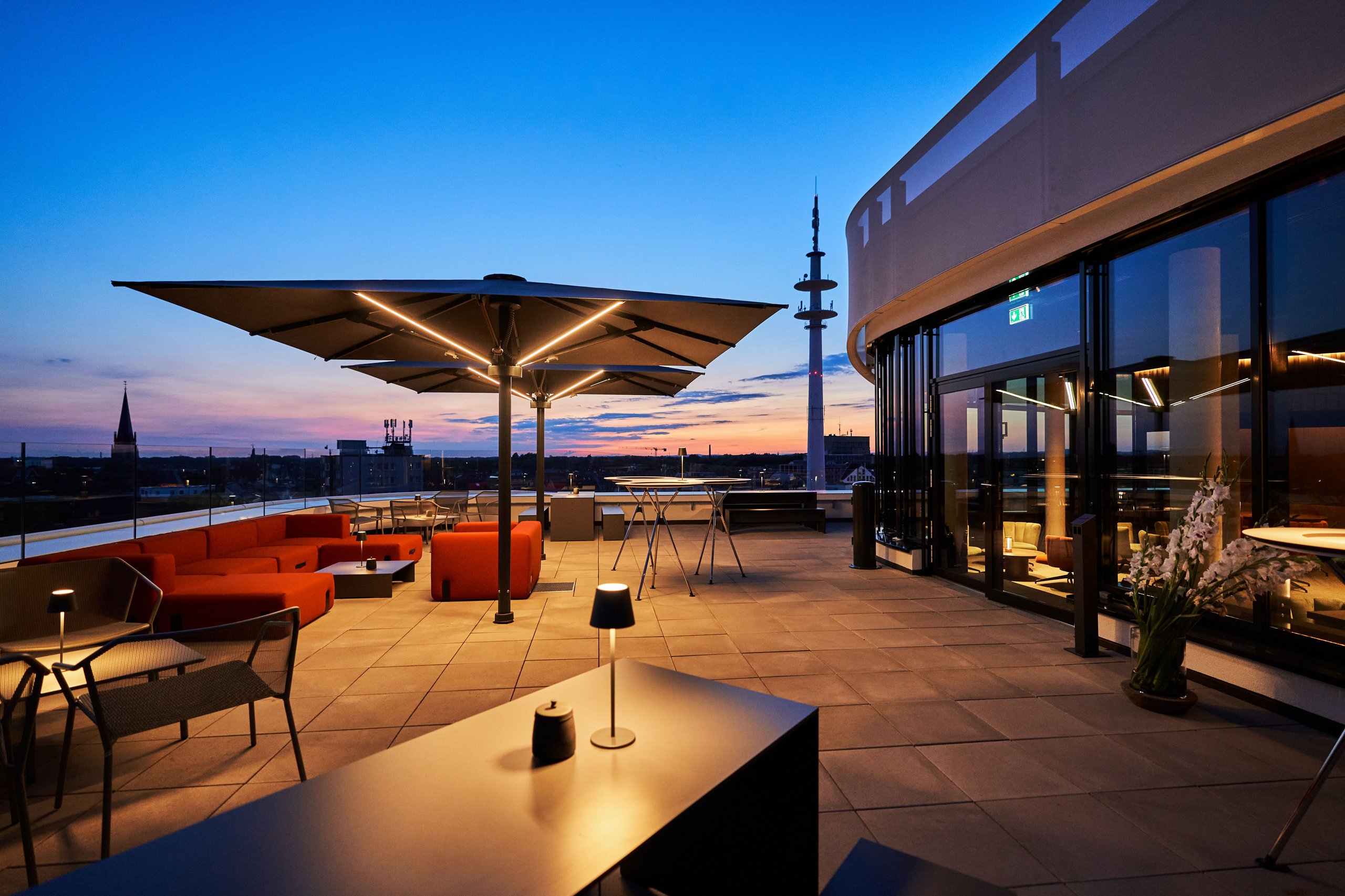 Palazzo-Noblesse-Schirme mit integrierter LED auf der Dachterrasse des Schüttflix Tower, Gütersloh, bei Sonnenuntergang