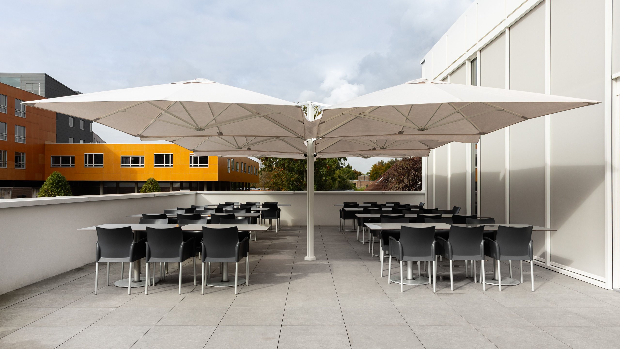 Zwei gekoppelte Prostor P6 in Weiß über der Bestuhlung einer modernen Terrasse
