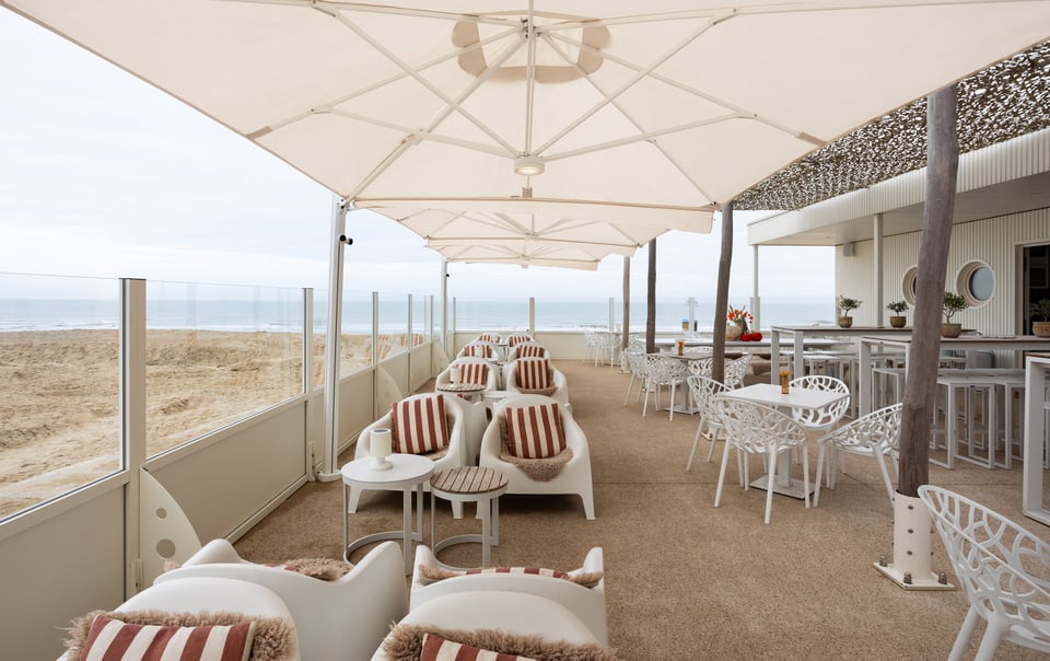 Gekoppelte Prostor P6 Schirmdächer in Reihe über einer Strandlounge
