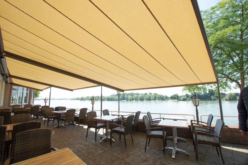 markilux pergola classic überspannt eine Restaurant-Terrasse am Wasser mit hellem Tuch
